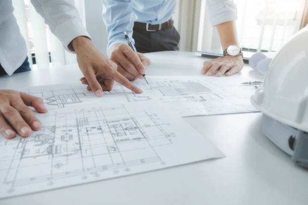 Engineer meeting for architectural project. working with partner Image of engineer meeting for architectural project. working with partner and engineering tools on workplace vintage tone. architecture engineering stock pictures, royalty-free photos & images