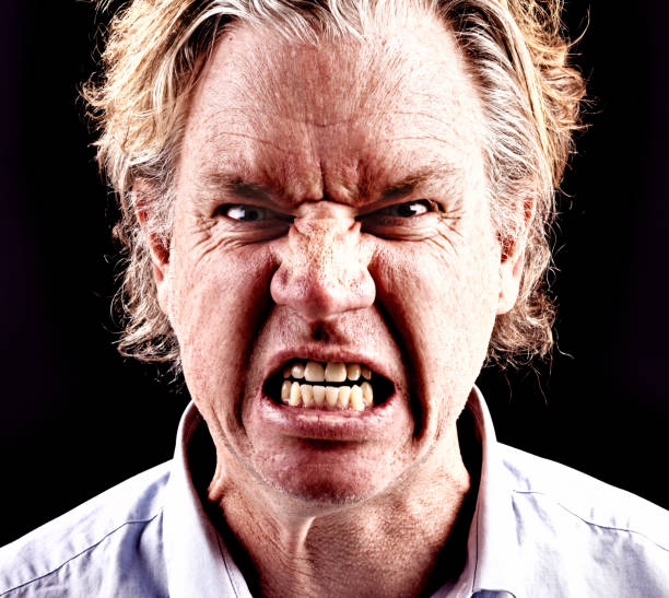 istock Furious middle-aged man snarls, frowning and grimacing 695455370