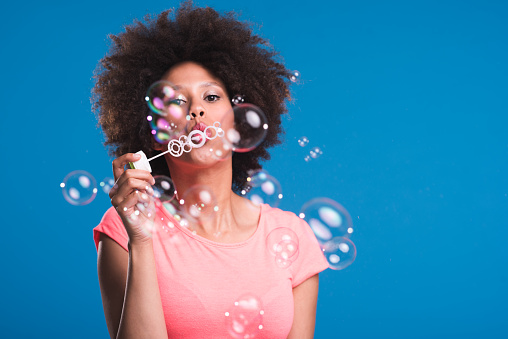 African American woman blowing bubbless