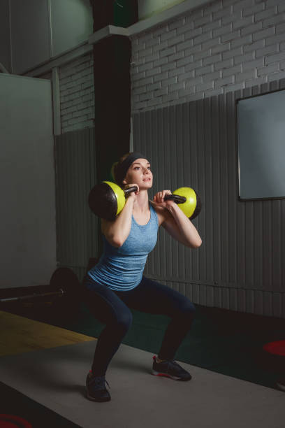istock Fitness woman training by kettlebell. Fit young lady doing exercise. 695460734