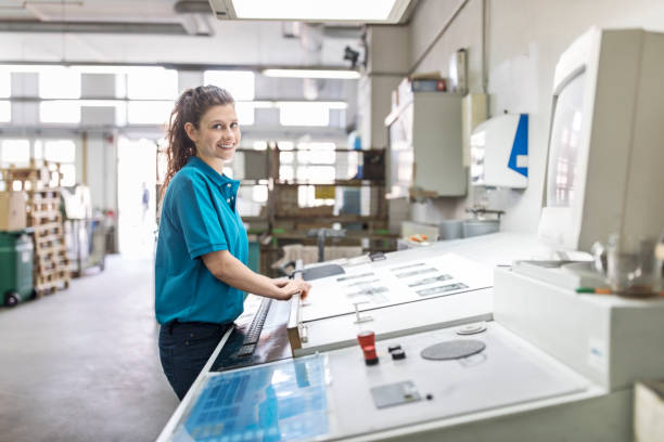 istock Happy female designer working in printing house. 695461746