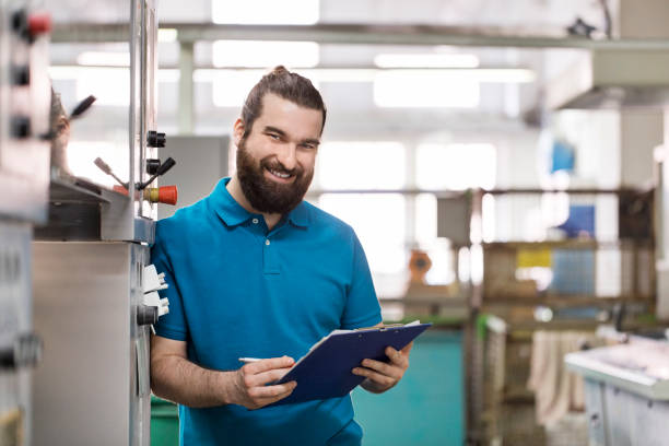 istock Happy male worker with clipboard at printing plant. 695466480