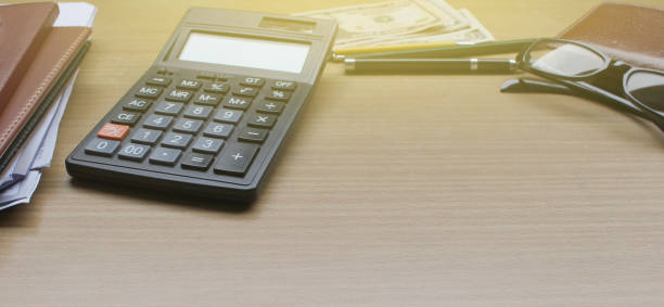 office desk with us dollars, smartphone with black screen, pen, calculator, wallet, and supplies with copy space - layman imagens e fotografias de stock