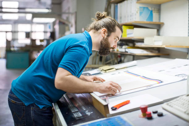 istock Designer examining the print run on table 695467394