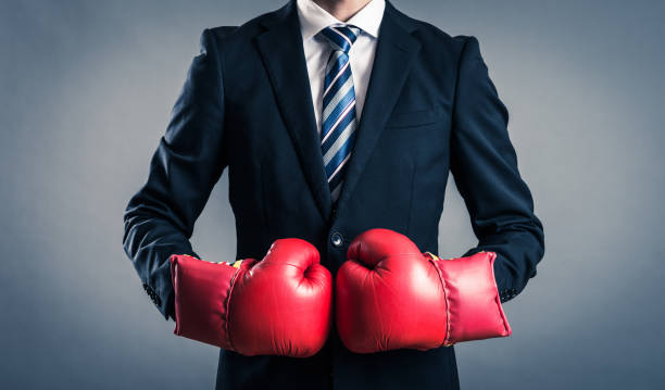 istock businessman with a boxing glove 695467470