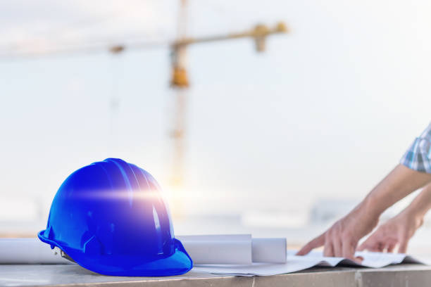 istock The blue safety helmet with the man verify blueprint for his project 695467556