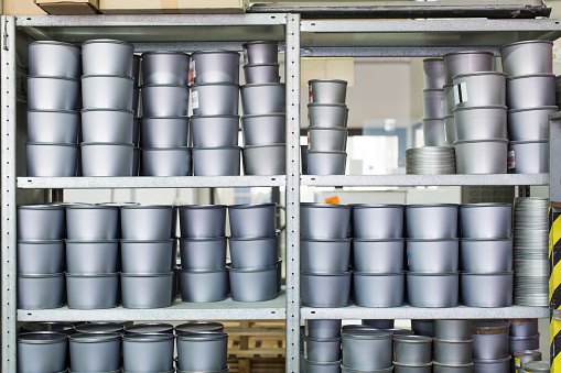 Ink pots stacked on shelf at printing factory.