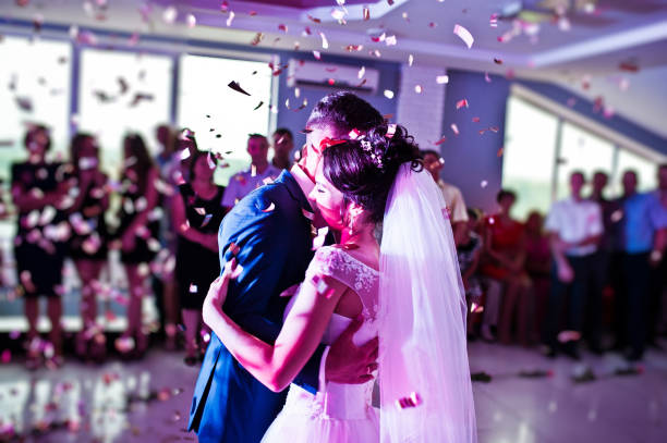 touching and emotional first dance of the couple on their wedding with confetti and colorful lights on the background. - women bride personal accessory adult imagens e fotografias de stock