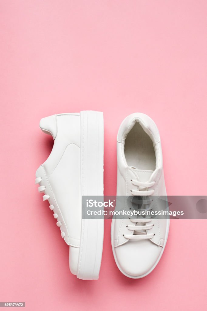 Overhead Shot de baskets blanches sur fond rose - Photo de Chaussures libre de droits