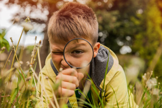 istock Child Exploring the Outdoors With Magnifying Glass 695479986