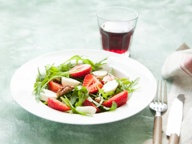 istock Fresh green salad with arugula, strawberry, cheese and walnuts. 695480332
