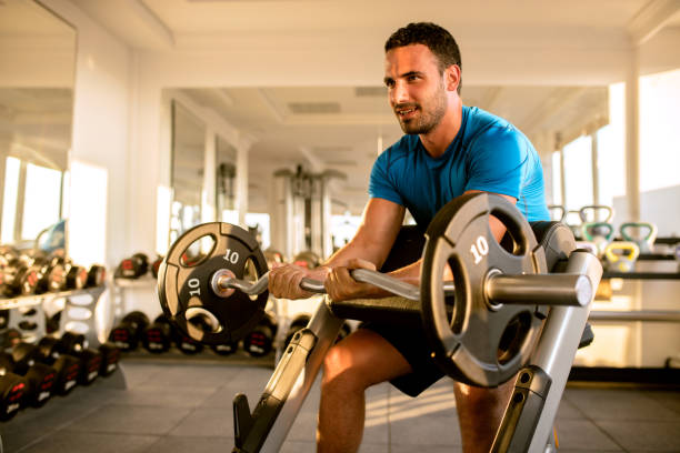 istock Fit man lifting dumbbells at  gym 695480582