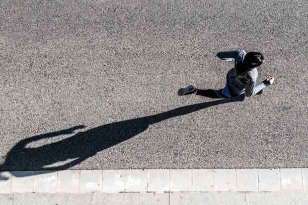 vista superior de jovem mulher fazendo cooper - running jogging road exercising - fotografias e filmes do acervo