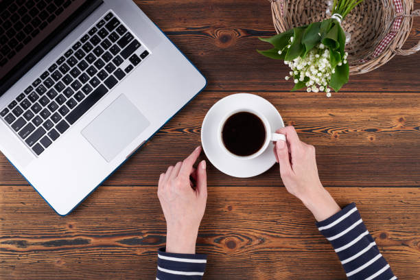 istock Woman with laptop on rough wooden table 695484026