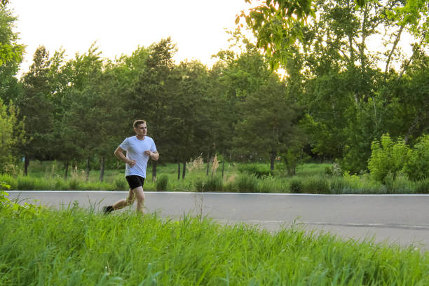 istock A guy runs in the summer on an asphalt road 695484404