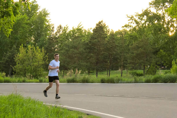 istock A guy runs in the summer on an asphalt road 695484406