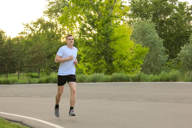 istock A guy runs in the summer on an asphalt road 695484410