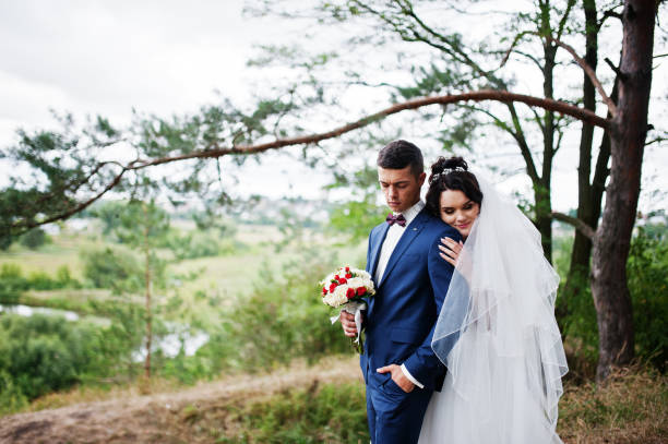 istock Beautiful young wedding couple admiring each other in a pine tree forest. 695484858