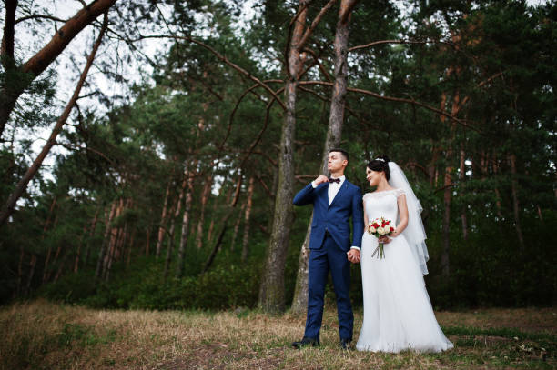 istock Beautiful young wedding couple admiring each other in a pine tree forest. 695485890