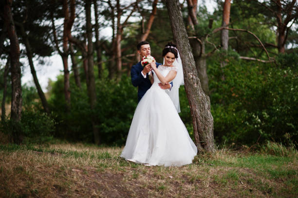istock Beautiful young wedding couple admiring each other in a pine tree forest. 695486056