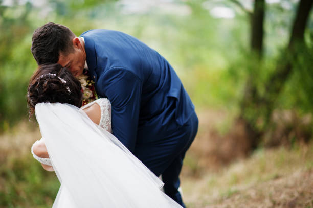 istock Beautiful young wedding couple admiring each other in a pine tree forest. 695486184
