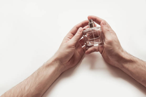 istock Men's hands hold a glass bottle with perfume 695489002