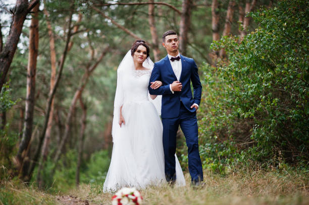 istock Beautiful young wedding couple admiring each other in a pine tree forest. 695489066