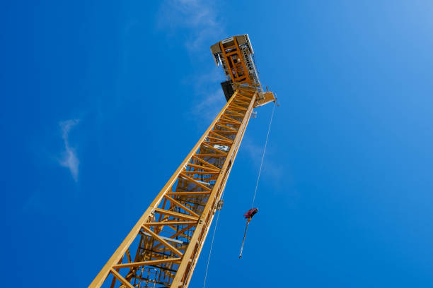 istock yellow construction crane isolated on blue sky background 695494818