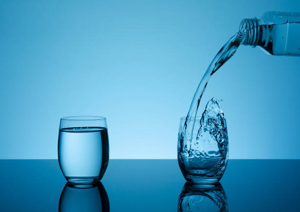 istock Bottle with creative splashing water in the glass 695495114