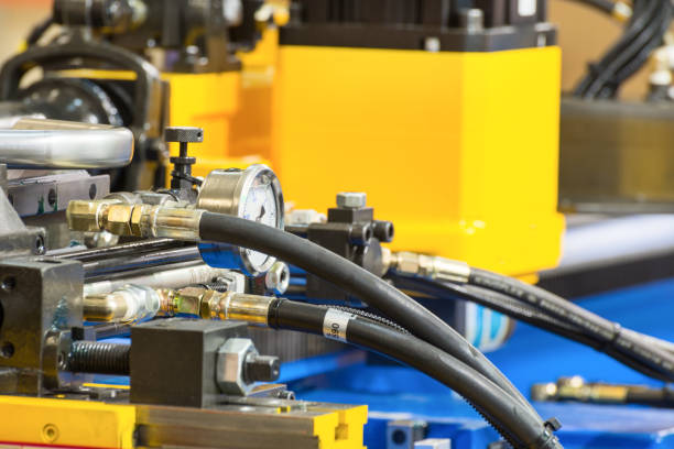 Rubber hydraulic hoses, connected to industrial equipment. Abstract industrial background.