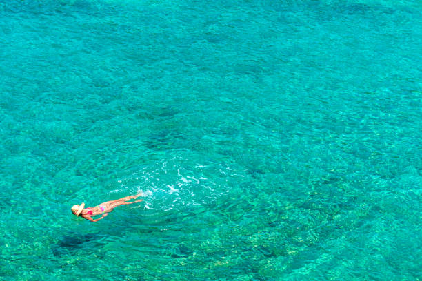 istock Girl floating in the sea 695495608