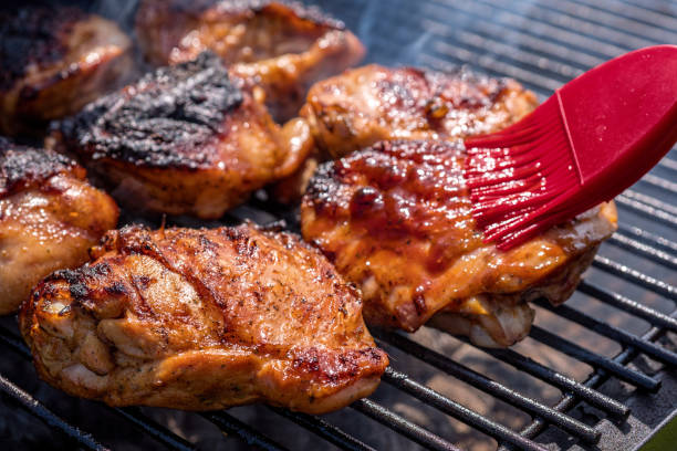 Grilled chicken thigh on the grill Grilled chicken thigh on the flaming grill drumstick stock pictures, royalty-free photos & images