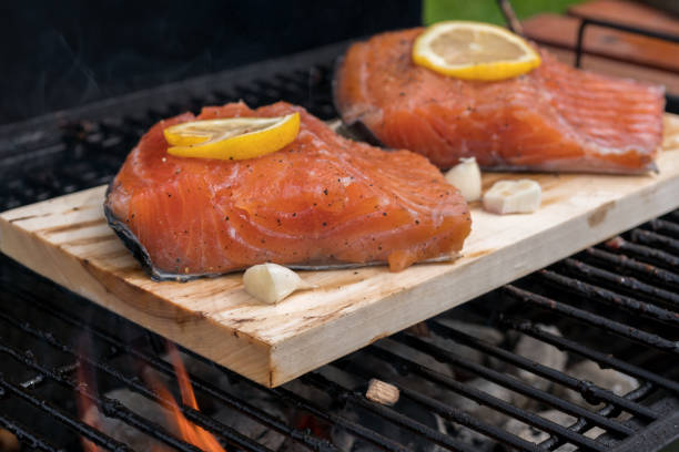 istock cedar plank salmon with lemon on a grill 695499692