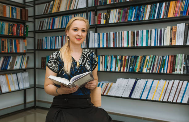 istock Education concept. Blonde woman with a book. 695508388