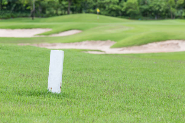 The white distance marker pole to inform range of golfing with blurred green golf course. The white distance marker pole to inform range of golfing with blurred green golf course. golf free bet site stock pictures, royalty-free photos & images
