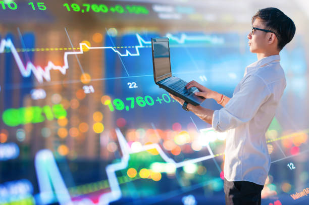 istock Young business man using laptop and digital tablet cityscape background 695512410