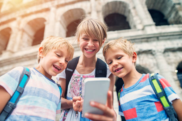 istock Kids tourists making selfie at Colosseum, Rome 695516580
