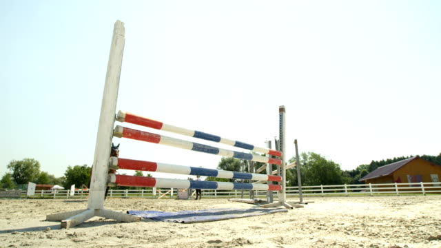 SLOW MOTION: Detail of horse legs knocking down the pole when jumping fences