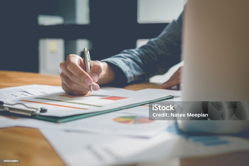 Businessman analyzing report on chart with laptop computer in office Business Meeting Stock Photo