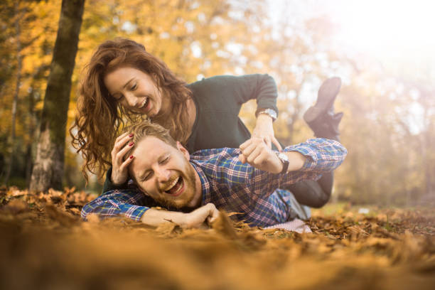 istock Cheerful redhead couple having fun while playing in autumn. 695519716