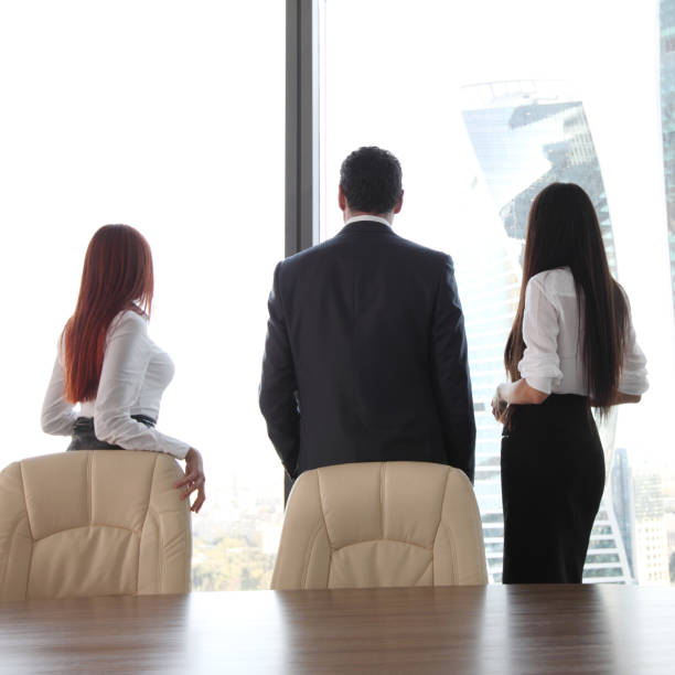 istock Business people looking at window 695530566