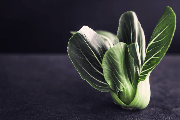 close up Fresh baby green bok choy on the black background , overhead or top view shot