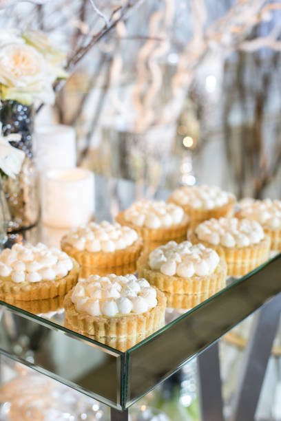 istock Cupcakes with white cream on the table decorated with white flowers and candles 695531120