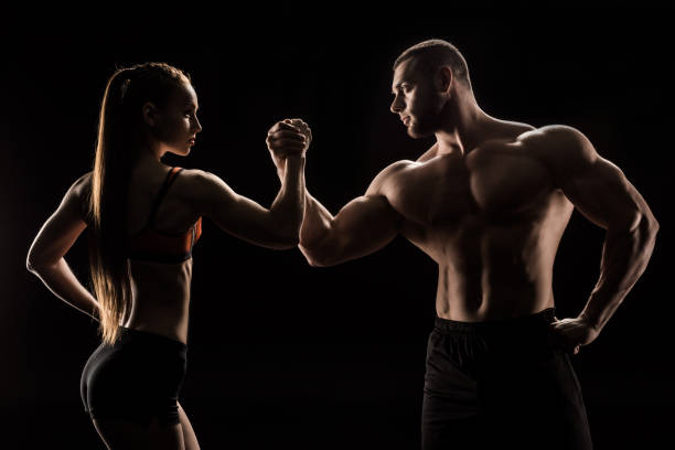 istock young sporty couple holding hands isolated on black 695555604