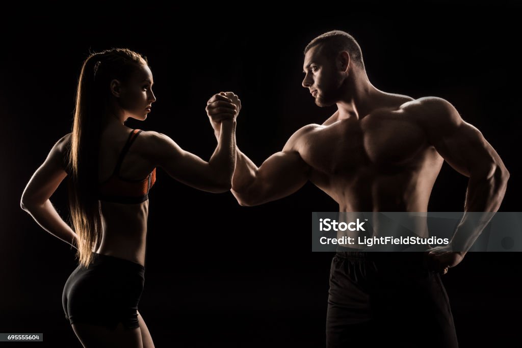 jovem casal desportivo isoladas no preto de mãos dadas - Foto de stock de Musculação royalty-free