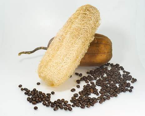 Luffa exfoliante con granos de café sobre fondo blanco. photo