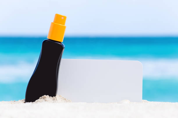 istock Blank white board and sunscreen protection cream on sand 695561234