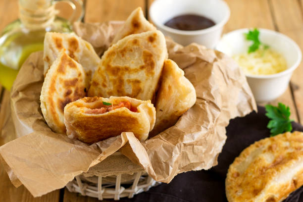 istock Fried flatbreads stuffed with ketchup, cheese and sausages 695570578