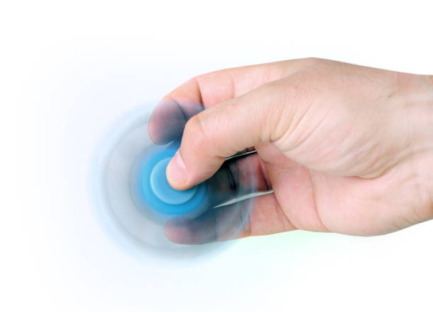 istock Male hand holding blue rotating fidget spinner 695574194