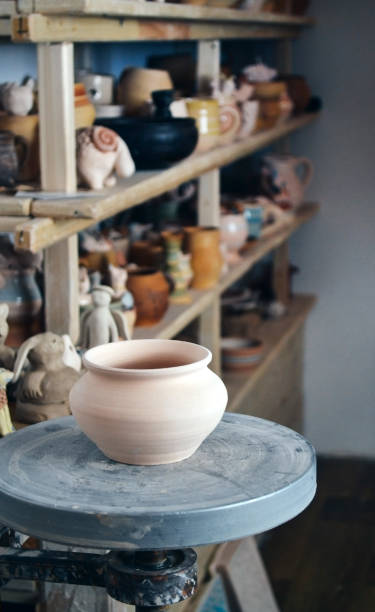 istock Clay pot in the foreground and shelves with pottery - on the second 695576512